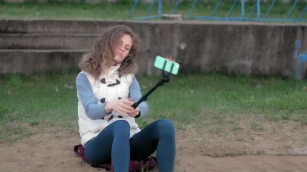 Bonita sonrisa chica tomar uno mismo foto selfie con teléfono inteligente móvil en el parque — Vídeo de stock