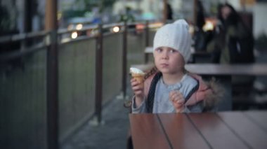 Beyaz örgü şapkalı dondurma yemek şirin bebek kız