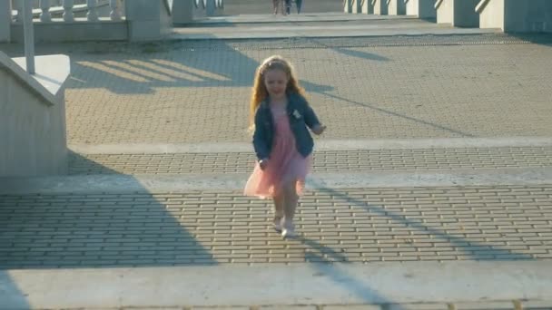 Маленькая счастливая девочка бегает по парку — стоковое видео