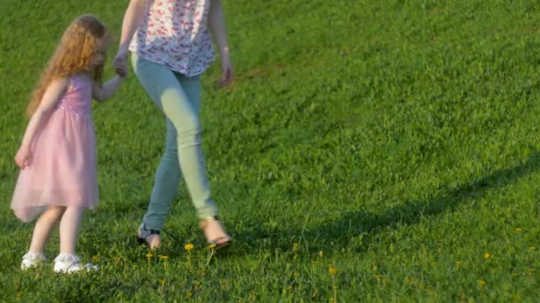 Mor och dotter vandrar i den soliga staden — Stockvideo