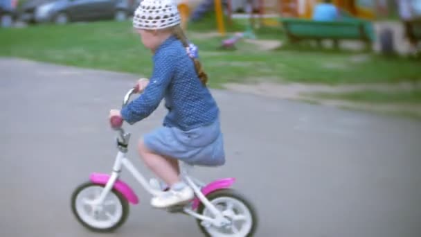 Lilla vackra flicka rider en cykel — Stockvideo