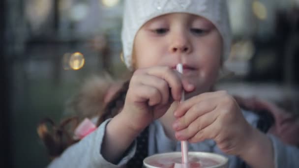 Χαριτωμένο μικρό παιδί κορίτσι σε λευκό πλεκτό καπέλο τρώγοντας παγωτό — Αρχείο Βίντεο