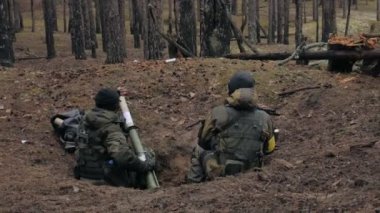 Kamuflaj savaş silahları ile askerler ormanın askeri kavram sığınakta pişirilir