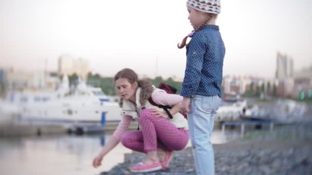 Little girl throwing a stone to the water — Stock Video