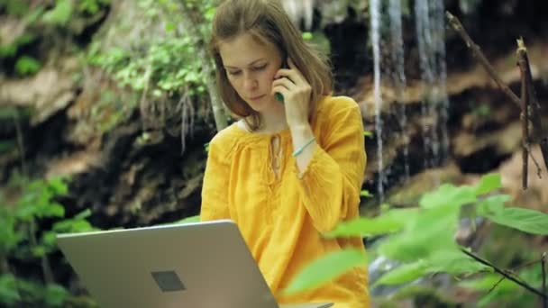 Dziewczyna z laptopa, siedzący na skale, w lesie — Wideo stockowe