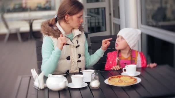 Mère et fille mangent et boivent au café à l'extérieur — Video