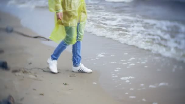 Mujer feliz caminando por la costa Viajando Estilo de vida aventura vacaciones al aire libre. Una chica vestida con un impermeable amarillo de moda — Vídeos de Stock