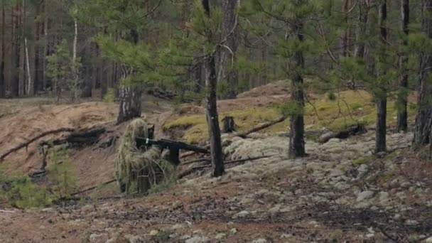 Soldados em camuflagem com armas de combate estão sendo disparados no abrigo da floresta, o conceito militar — Vídeo de Stock