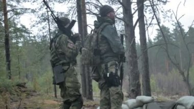 Kamuflaj savaş silahları ile askerler ormanın askeri kavram sığınakta pişirilir