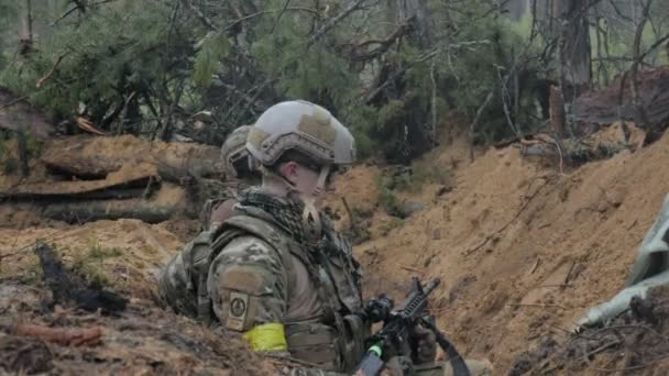 Soldados en camuflaje con armas de combate están siendo disparados en el refugio del bosque, el concepto militar — Vídeos de Stock