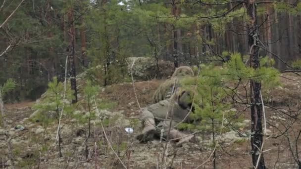 Soldados en camuflaje con armas de combate están siendo disparados en el refugio del bosque, el concepto militar — Vídeo de stock