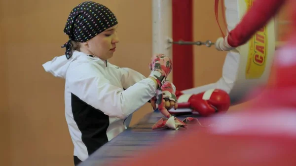 En el gimnasio pone un vendaje elástico en la mano de las mujeres al boxeador antes del entrenamiento . — Foto de Stock