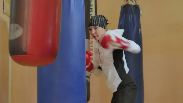 Boxing woman training punching bag in fitness studio fierce strength fit body kickboxer series — Stock Photo, Image