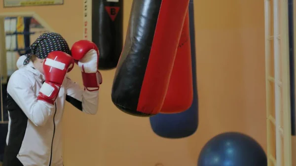 Boksz nő képzés boxzsák a fitness stúdió heves erő fit test kickboxer sorozat — Stock Fotó