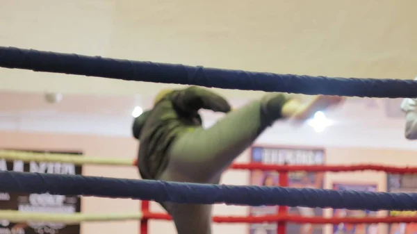 Der Trainer führt einen Trainingskampf mit einer Kickboxerin im Ring — Stockfoto