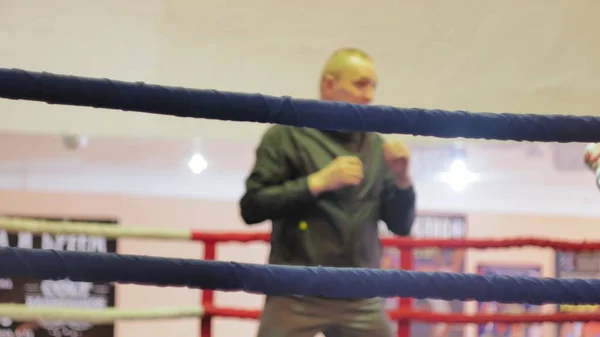 L'entraîneur mène une bataille d'entraînement avec une femme kickboxer dans le ring — Photo