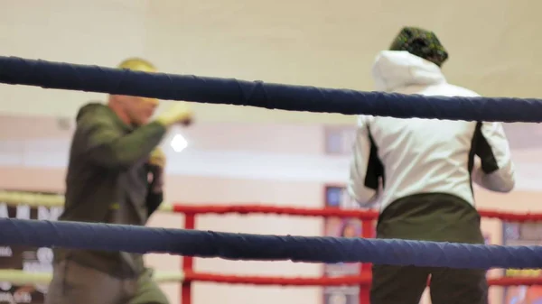 Ο εκπαιδευτής διεξάγει μια κατάρτιση μάχη με ένα θηλυκό kickboxer στο δαχτυλίδι — Φωτογραφία Αρχείου