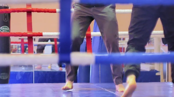 El entrenador lleva a cabo una batalla de entrenamiento con una kickboxer femenina en el ring — Foto de Stock