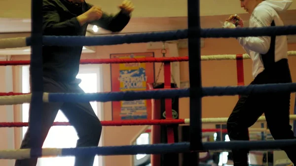 トレーナーはリングで女性キック ボクサーと訓練の戦いを行っています — ストック写真