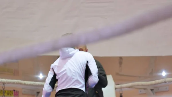 Der Trainer führt einen Trainingskampf mit einer Kickboxerin im Ring — Stockfoto
