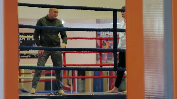 Тренер проводит тренировочный бой с кикбоксером на ринге — стоковое фото