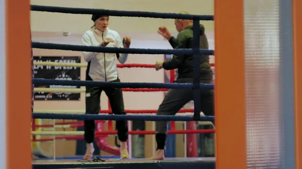Bir kadın kick boks halka ile bir eğitim savaş eğitmen yürütmektedir — Stok fotoğraf