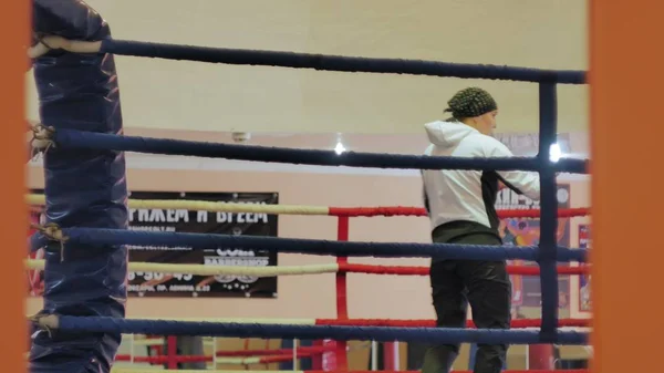 El entrenador lleva a cabo una batalla de entrenamiento con una kickboxer femenina en el ring —  Fotos de Stock