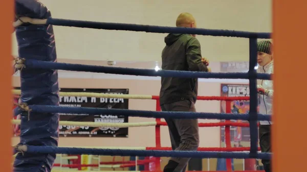 The trainer conducts a training battle with a female kickboxer in the ring — Stock Photo, Image