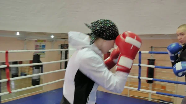 De trainer voert een strijd van de opleiding met een vrouwelijke kickboxer in de ring — Stockfoto