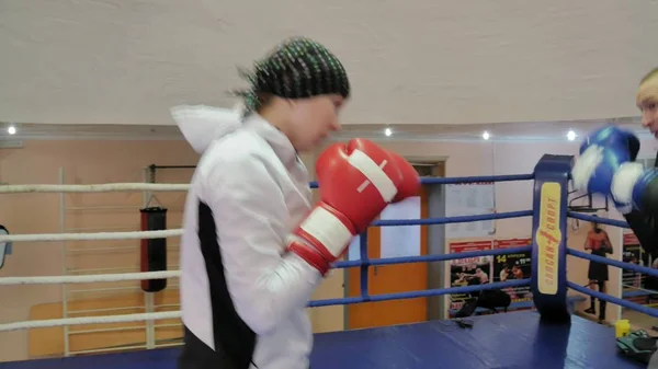 L'entraîneur mène une bataille d'entraînement avec une femme kickboxer dans le ring — Photo