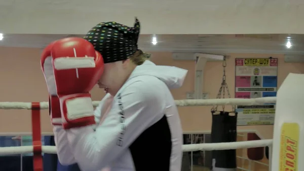 O treinador conduz uma batalha de treinamento com uma mulher kickboxer no ringue — Fotografia de Stock