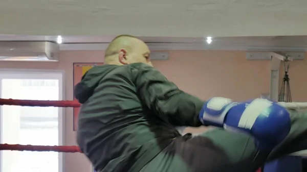 De trainer voert een strijd van de opleiding met een vrouwelijke kickboxer in de ring — Stockfoto