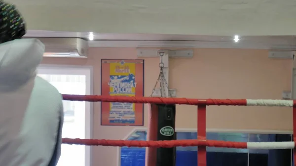 El entrenador lleva a cabo una batalla de entrenamiento con una kickboxer femenina en el ring —  Fotos de Stock
