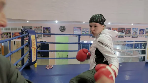 L'allenatore conduce una battaglia di allenamento con le zampe con una kickboxer donna sul ring — Foto Stock