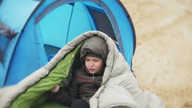 Nehir kıyısında turist çadır. Kız çadır oturur ve nehirde görünüyor.
