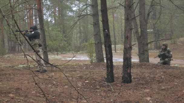 Soldater i kamouflage med bekämpa vapen gör sin väg utanför skogen, med syftet att fånga det, militära konceptet — Stockvideo