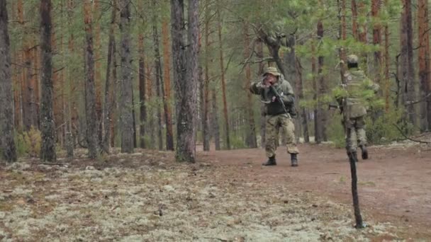 Soldaten in Tarnkleidung mit Kampfwaffen bahnen sich ihren Weg aus dem Wald, um ihn einzufangen, das militärische Konzept — Stockvideo