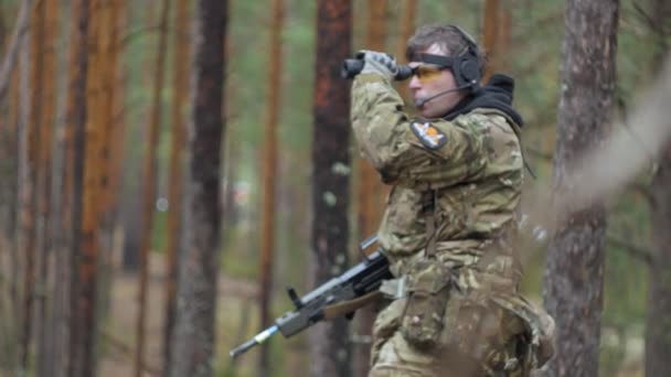 Soldados en camuflaje con armas de combate están siendo disparados en el refugio del bosque, el concepto militar — Vídeo de stock