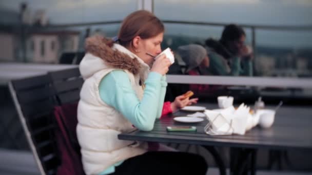 Moeder en dochter eten en drinken in café buiten — Stockvideo