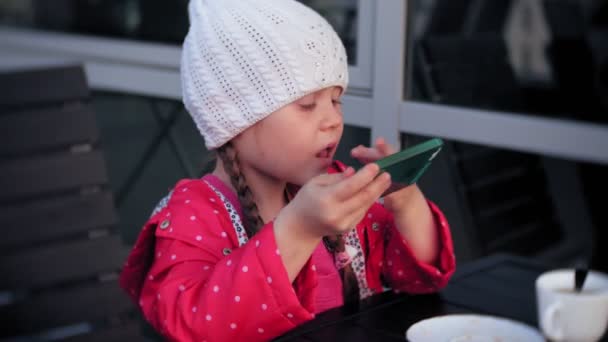 Mother and daughter eat and drink in cafe outside — Stock Video