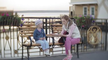 Kadın parkta bebekle. Anne kızına bir bahar parkta konuşuyor.