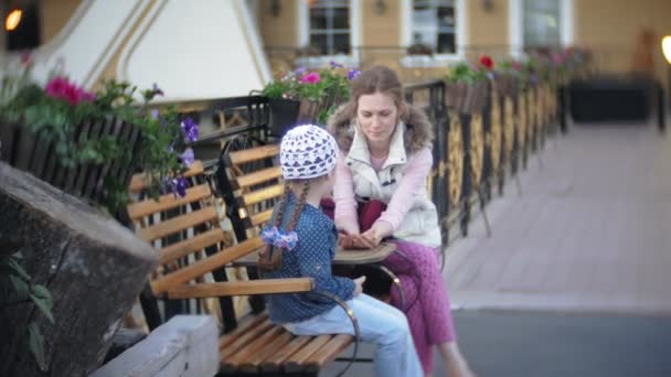 Kadın parkta bebekle. Anne kızına bir bahar parkta konuşuyor. — Stok video