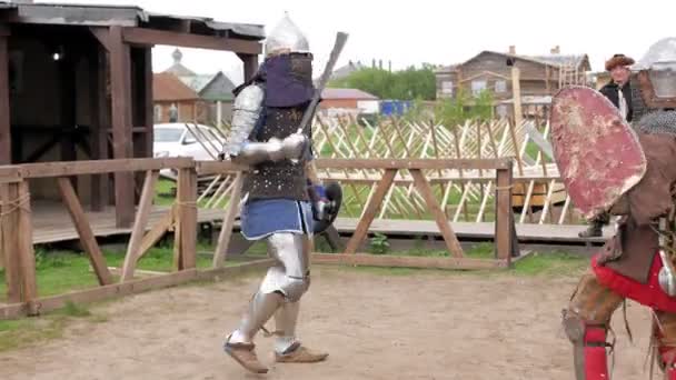 Knights in steel armor and chain mail helmets fighting at medieval tournament — Stock Video