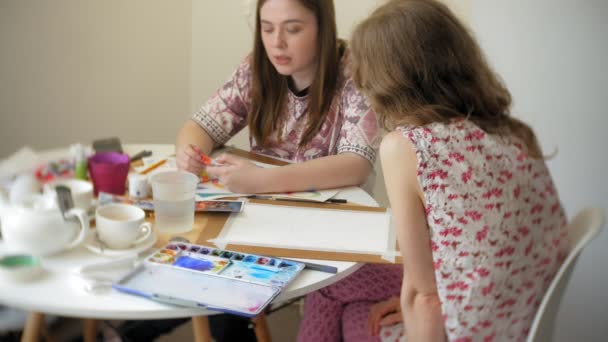 Két fiatal nő művész festő otthon stúdió kreatív eszközök — Stock videók