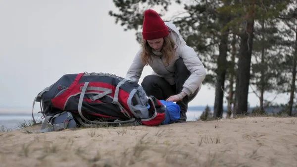 빨간 모자에 매력적인 젊은 관광 여자 해안 숲 근처 관광 텐트를 수집 — 스톡 사진