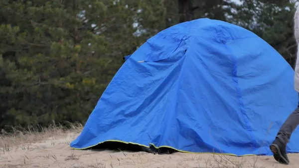 Çekici genç turist kadın kırmızı şapkalı bir turist çadır forest yakınındaki sahil üzerinde toplar. — Stok fotoğraf