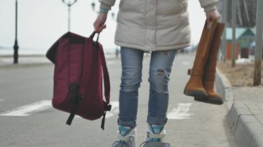 Sportif sıcak giysiler ve Silindirler, deniz kenarı yolda sürme giyen genç güzel kadın kırmızı şapkalı