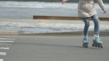 Sportif sıcak giysiler ve Silindirler, deniz kenarı yolda sürme giyen genç güzel kadın kırmızı şapkalı