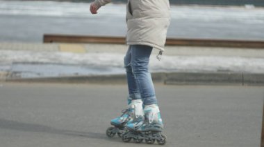 Sportif sıcak giysiler ve Silindirler, deniz kenarı yolda sürme giyen genç güzel kadın kırmızı şapkalı