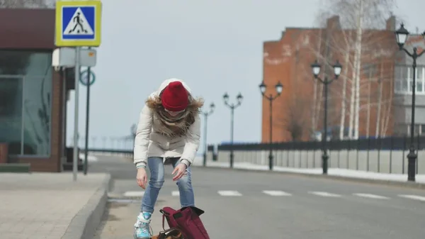 Young beautiful woman in a red hat, wearing sporty warm clothes and rollers, riding on the road on the coast — Stock Photo, Image